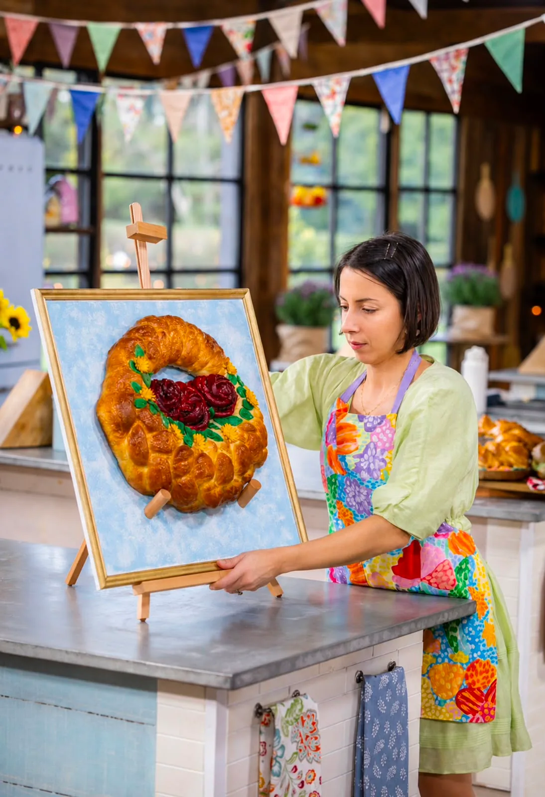 Pam placing a framed challah wreath on an easel